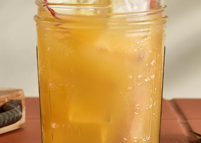 A glass of Cruzan® Cider Punch garnished with Cinnamon Sticks and Apple Slices 