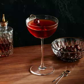 A glass of Baker's® Midnight Manhattan garnished with Cherry 