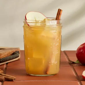 A glass of Cruzan® Cider Punch garnished with Cinnamon Sticks and Apple Slices 