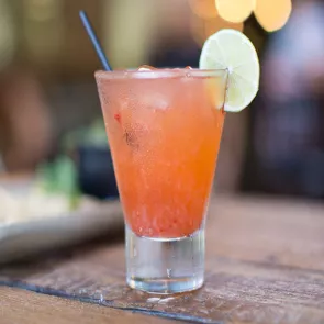 A glass of Orangesicle garnished with lemon slice and a straws 