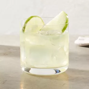 A glass of DeKuyper® End of the Rainbow garnished with Green Apple Slices and Lime Wheel