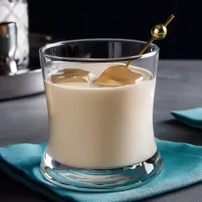 Glasses of White Russian with ice and cocktail pick on a blue napkin