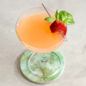 A glass of Japanese Gin Sour garnished with strawberry and mint leaves 