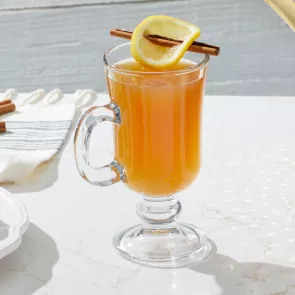 A glass of Maker's Mark® Hot Apple Cider garnished along with  a Cinnamon Stick, Lemon Whee