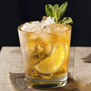 Glass of Whisky Smash garnished with crushed ice and mint leaves