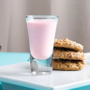 A glass of Oatmeal cookie accompanied with cookies on a  white tray