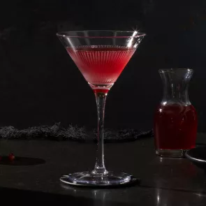 A glass of Pinnacle® Black Widow Martini alongside small bottle of red liquid