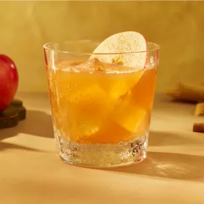 A glassof SQRRL® An Apple A Day garnished with Fresh Apple Slices 