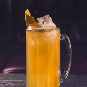 Mug of Lemon Tell You Somethin’ Honey garnished with ice cubes and lemon peel