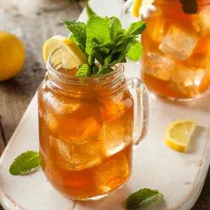 A pitcher of Harbor Punch garnished with lemon slice and fresh mint.