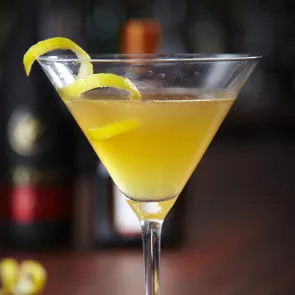 A cocktail glass of Cruzan® Sidecar garnished with peeled lemon.