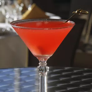 A glass of Cran-Apple Martini with a cocktail pick