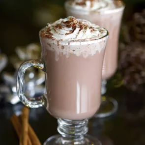 Mug of Spicy Hot Chocolate garnished with whipped cream and cinnamon.