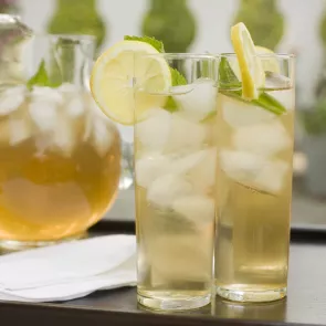 Two glasses of Beam Ade garnished with lemon slices and mint leaves.