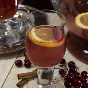 Glass of Cranberry Cooler garnished with orange slice and cherries