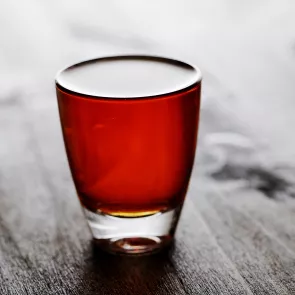 a glass of Fire Apple garnished with a lime wedge