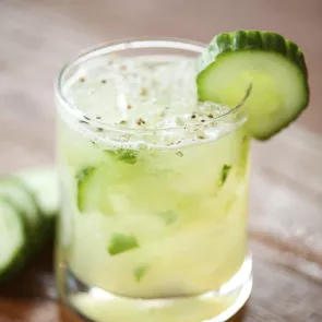 Glass of Honey Apple Cucumber garnished with a cucumber slice on the rim