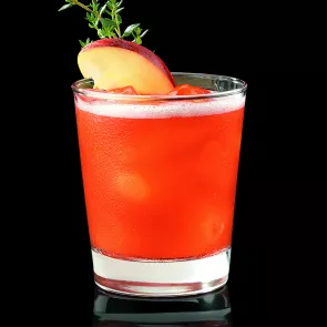 a glass with a Apples and Bourbon garnished with apple slice