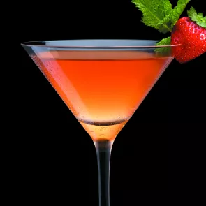 Glass of strawberry Julep garnished with strawberries and mint leaves.