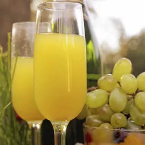 Two glasses of Alligator's Kiss, accompanied by a bowl full of grapes.