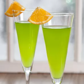 Two glasses of Midori® Orange and Sparkling garnished with an orange wedge.