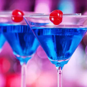 Two glass of Blue Martini garnished with cherry on a rim of glass