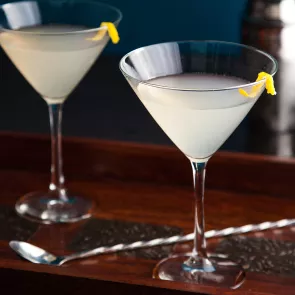 Two glasses of Classic Lemon Drop, each garnished with a lemon peel on the rim of the glass