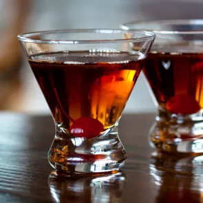 Two glasses of Classic Manhattan, each garnished with a cherry