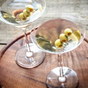 Two glasses of Dirty Martini garnished with olives