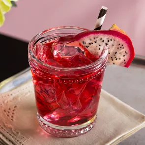  A glass of Paris Dream garnished with slice of dragon fruit and a straw