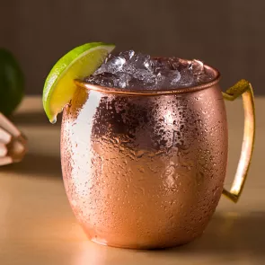 a copper mug of Moscow Mule garnished with ice and lime wedge