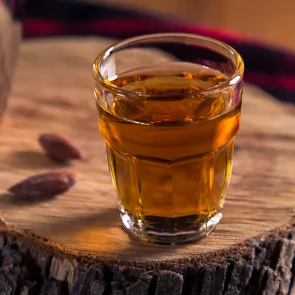 Glass of Tree Trimmer on a wooden log.